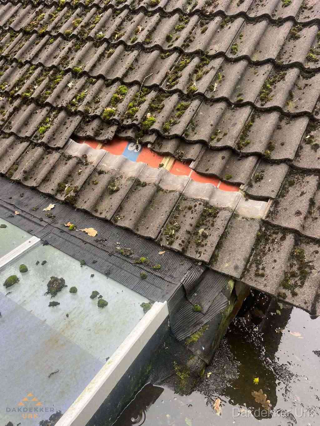 Beschadigd pannendak met ontbrekende dakpannen voor reparatie in Urk