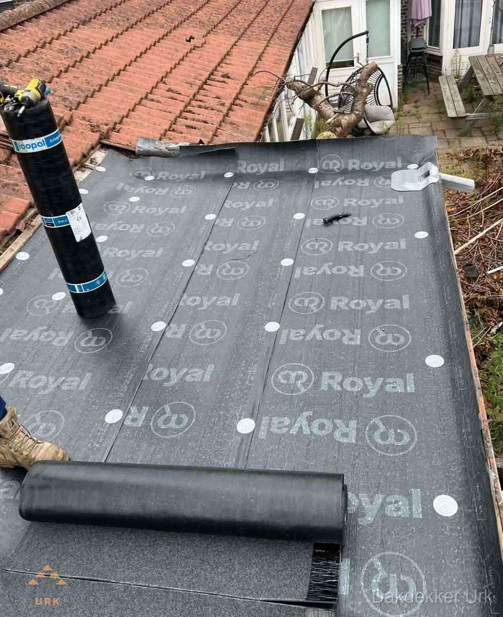 Plat dak met nieuwe bitumen dakbedekking en brandgereedschap in Urk