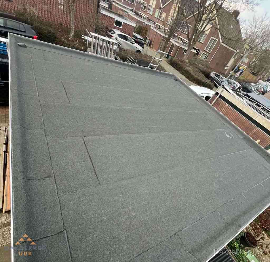 Nieuwe bitumen dakbedekking op plat dak van garage in Urk