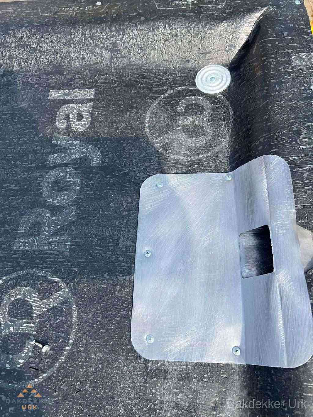 Dakdoorvoer met metalen afvoerplaat op bitumen dak in Urk