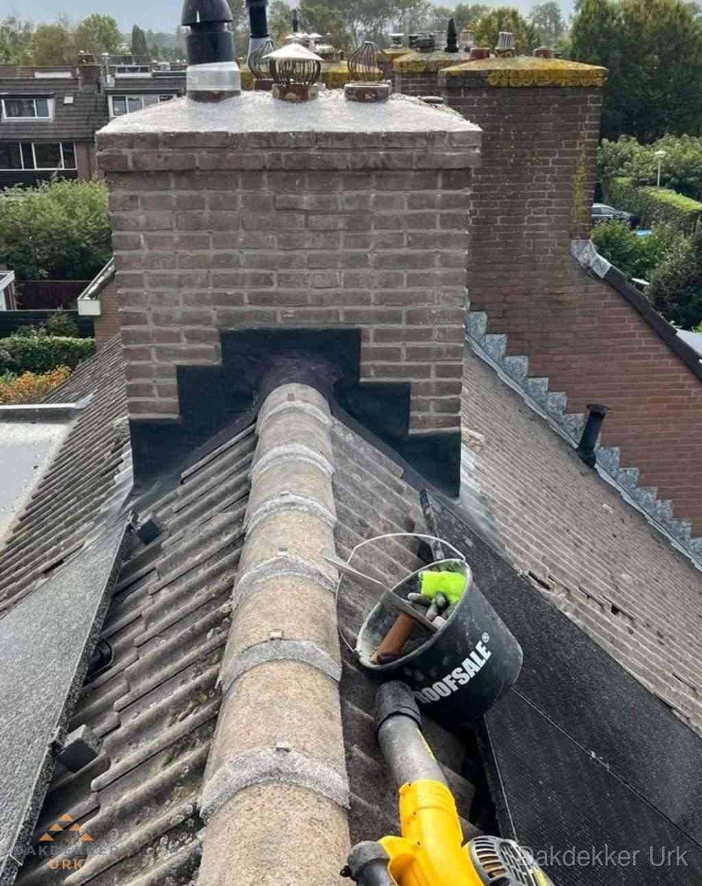 Dakdekker repareert bitumen dakleer bij dakdoorvoer in Urk